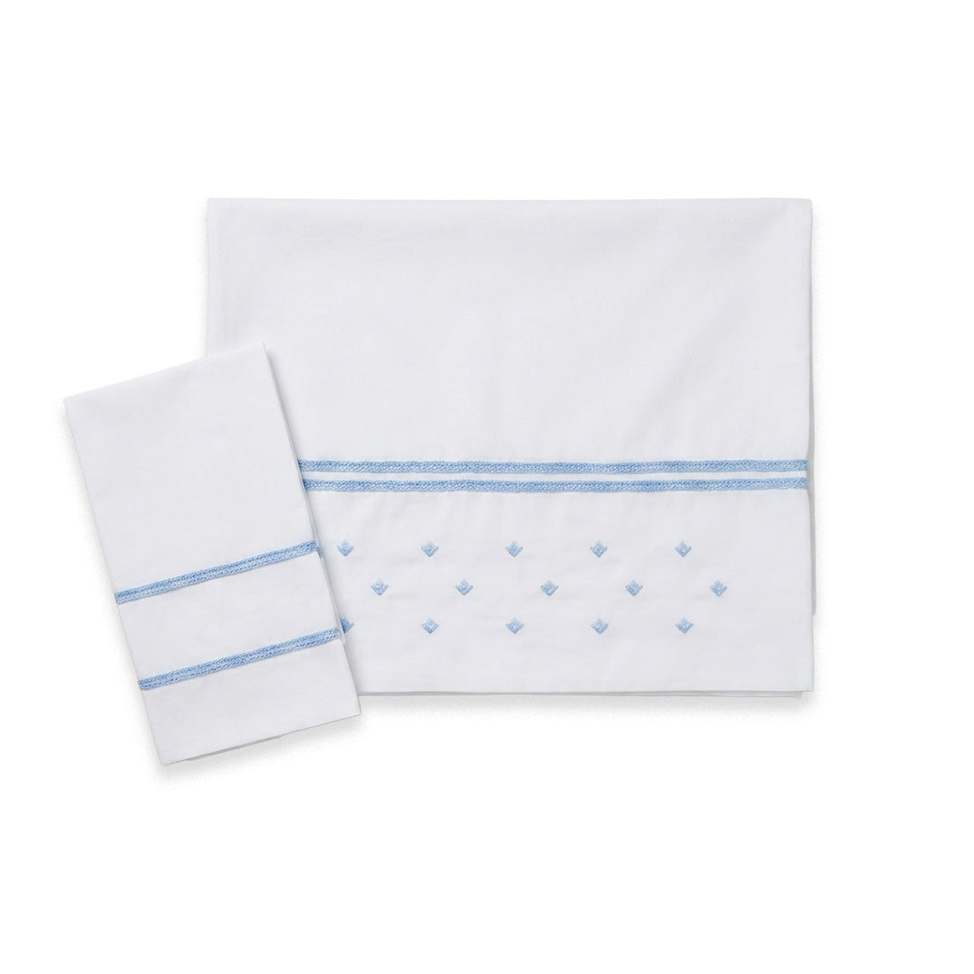 Set Lenzuolino per culla bianco latte con ricami azzurri e dettagli sartoriali